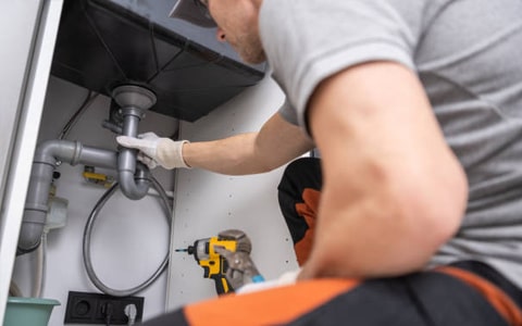 Blue8 Gas Services engineer repairing a burst pipe under a bathroom sink. Blue8 Gas Services engineer repairing a burst pipe under a bathroom sink.
