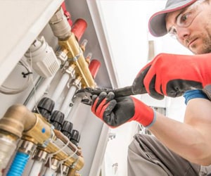 Gas Safe engineer inspecting a modern boiler during a home visit.